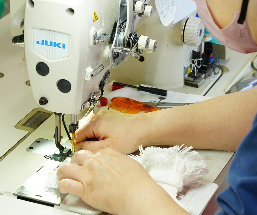 染色前のモップを縫製中